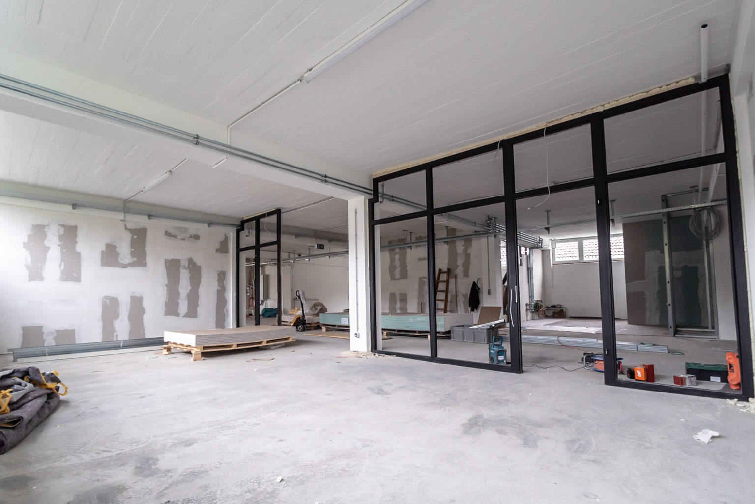 Interior empty office light room in a new building renovation or under construction. Glass doors and Windows.